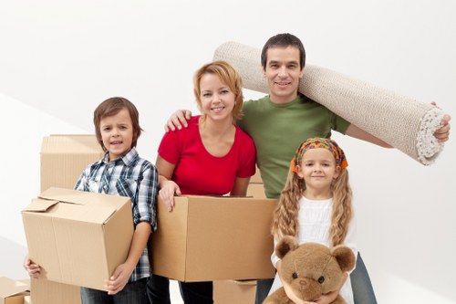Removal team handling boxes and furniture in a Lea Bridge flat move